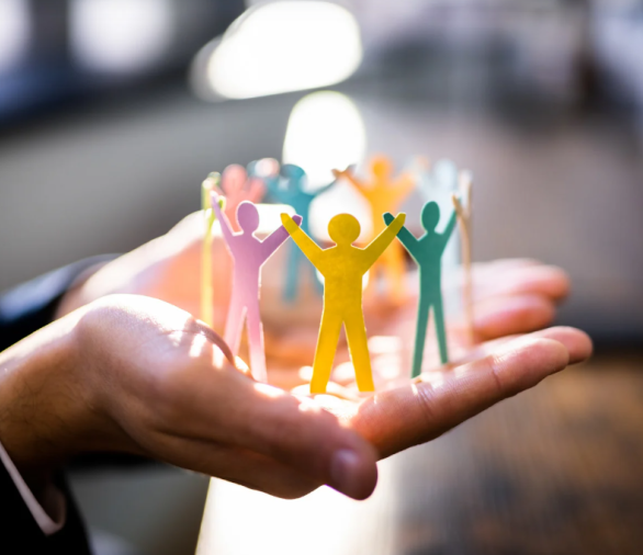 Geknipte papierenpoppetjes die in handen worden vast gehouden 