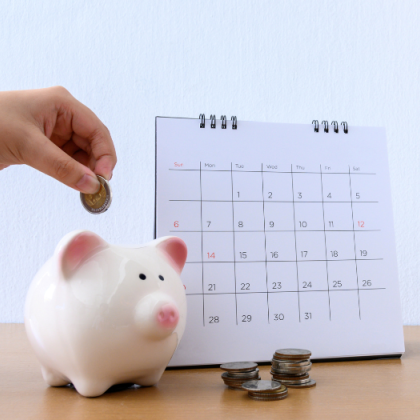 spaarvarkentje met geld en een kalander ernaast 